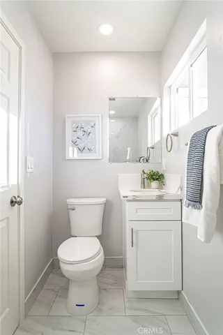a spacious bathroom with a toilet sink and mirror