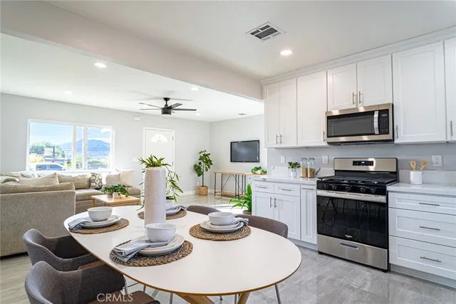 a kitchen with stainless steel appliances kitchen island granite countertop a kitchen island hardwood floor sink stove and dining table