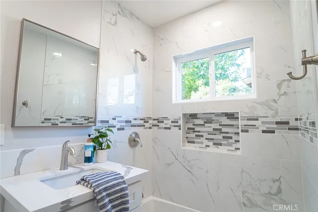 a bathroom with a granite countertop sink and a mirror