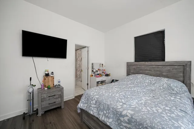 a bedroom with a bed and a flat screen tv