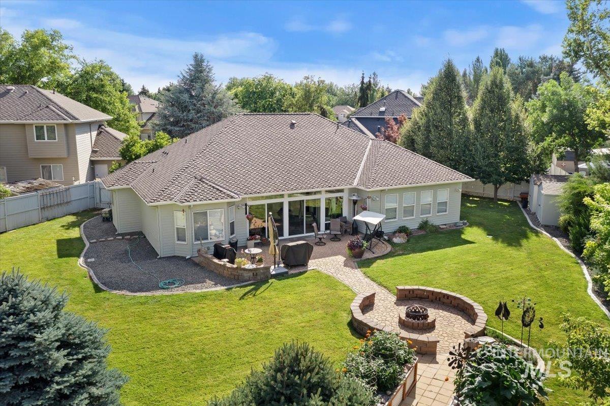 5184 North Greyloch Way Boise, ID 83704 - Photo 4 of 32 Expansive backyard featuring a stone paver patio, integrated fire pit with stone seating, and a dedicated stone paver pathway