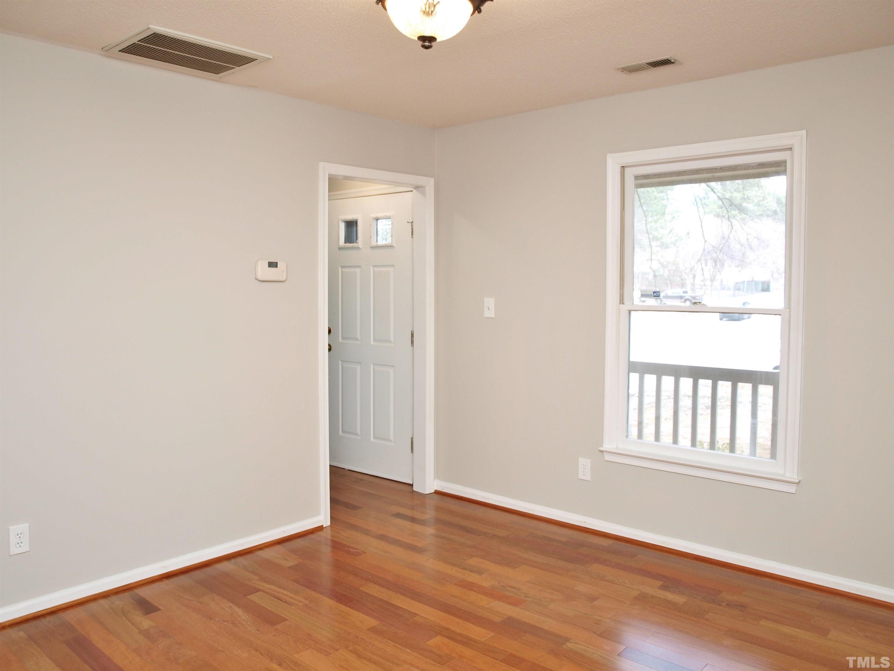 4509 Lafferty Court Raleigh, NC 27616 - Photo 5 of 17 an empty room with wooden floor and windows