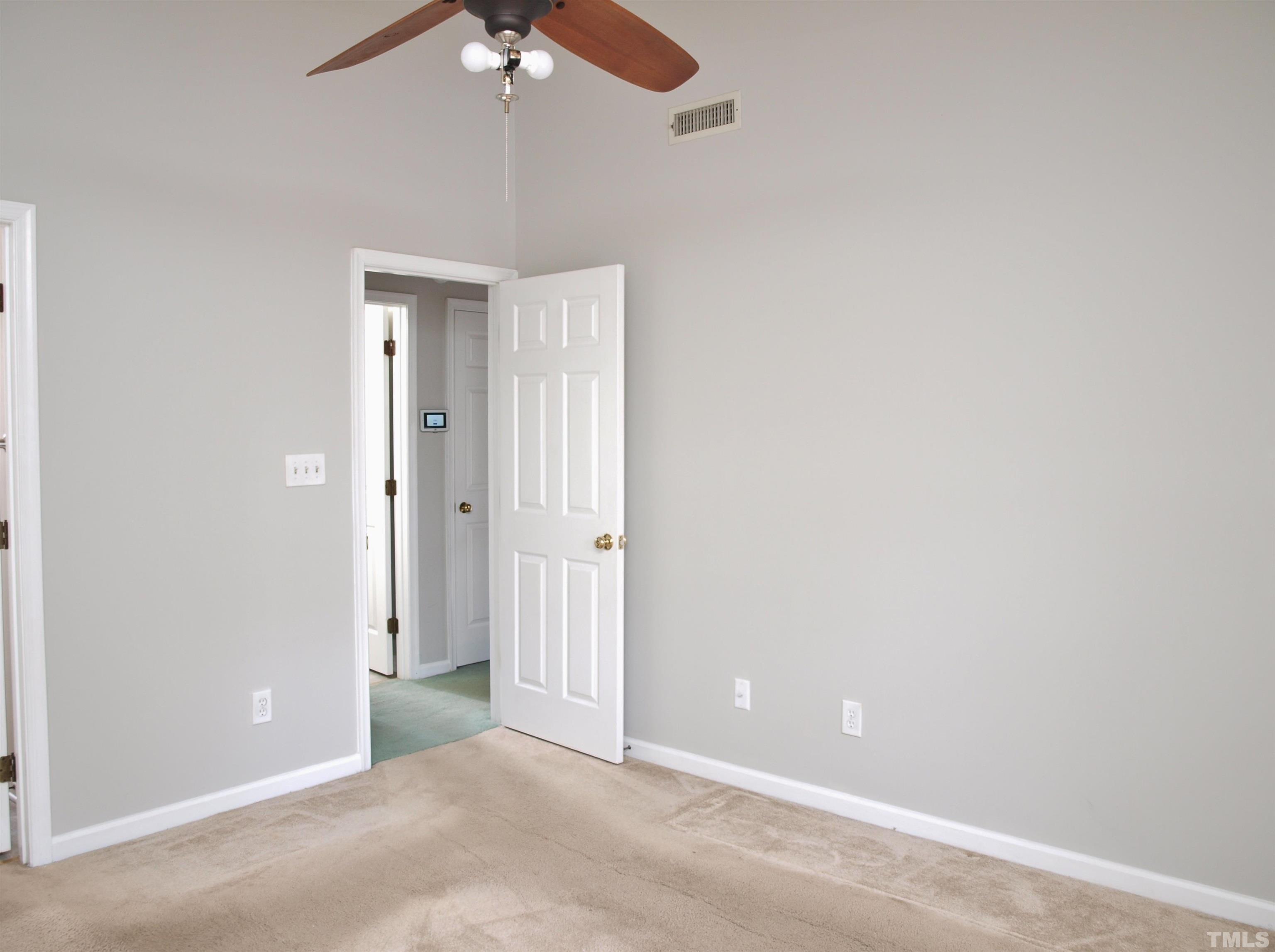 4509 Lafferty Court Raleigh, NC 27616 - Photo 8 of 17 an empty room with a chandelier fan and windows