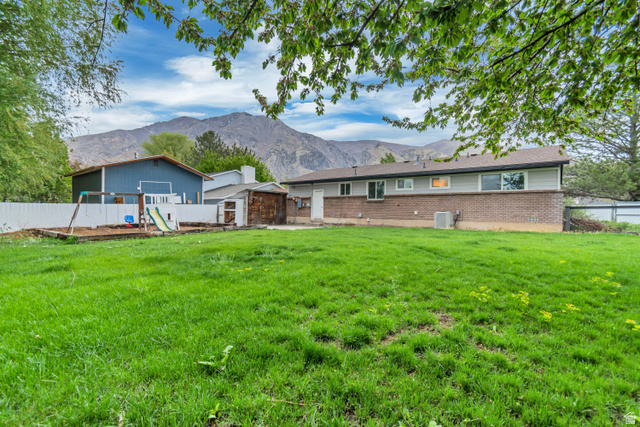 495 North 250 West Springville, UT 84663 - Photo 28 of 35 Rear view of property with a playground, a fenced backyard, a mountain view, and brick siding