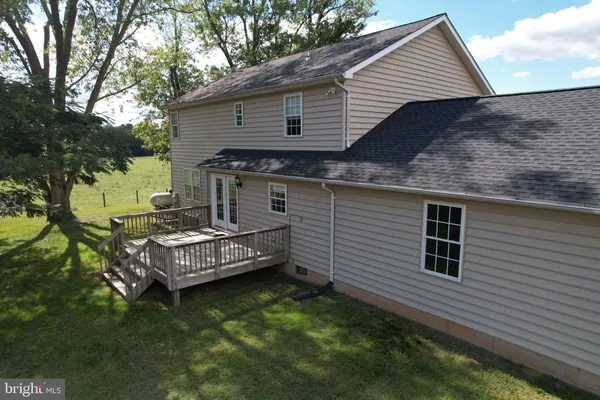 a view of a house with a yard chairs and large tree