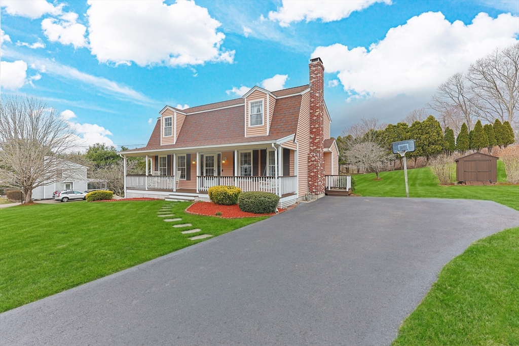 a front view of a house with a yard and potted plants