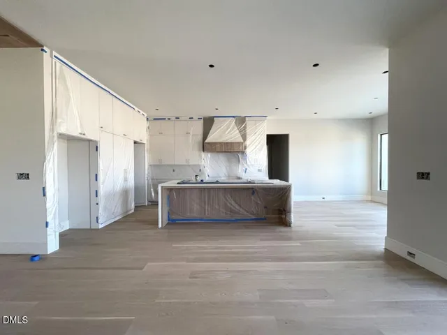 a view of an empty room with a fireplace and a window