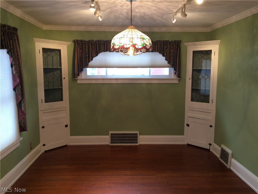 4009 Rosemond Road Cleveland Heights, OH 44121 - Photo 7 of 28 Dining room has a touch of splash with accent lighting, corner cabinets, crown molding, wood floor, and 8" baseboard.