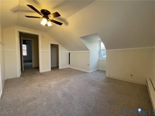 an empty room with ceiling fan and window