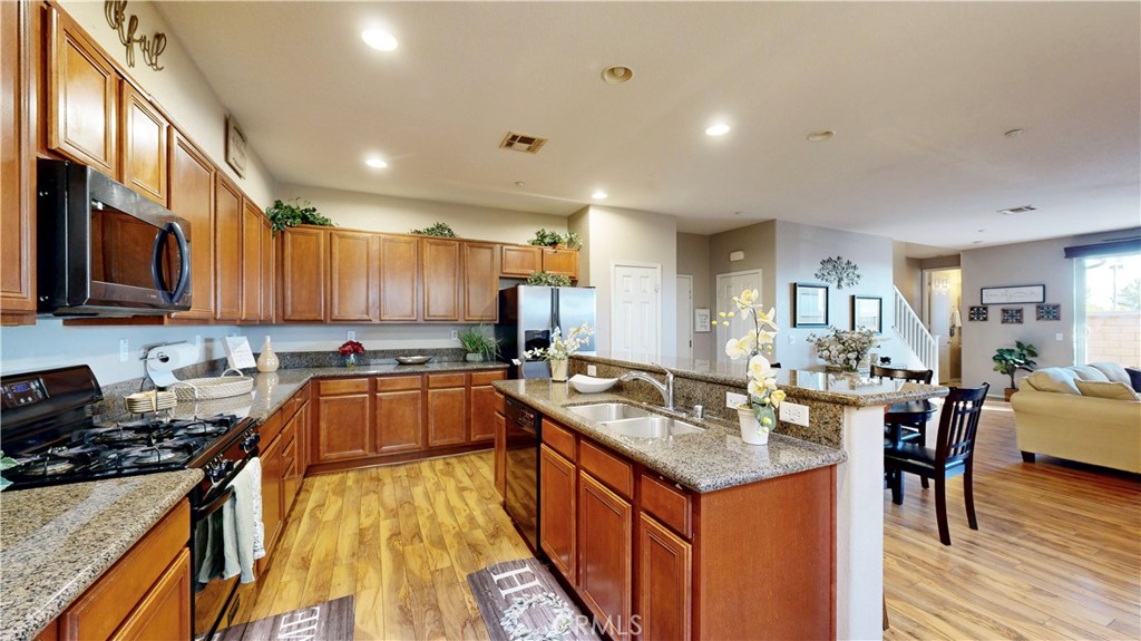 10375 Church Street, Unit 100 Rancho Cucamonga, CA 91730 - Photo 11 of 29 a kitchen with a stove sink cabinets and wooden floor
