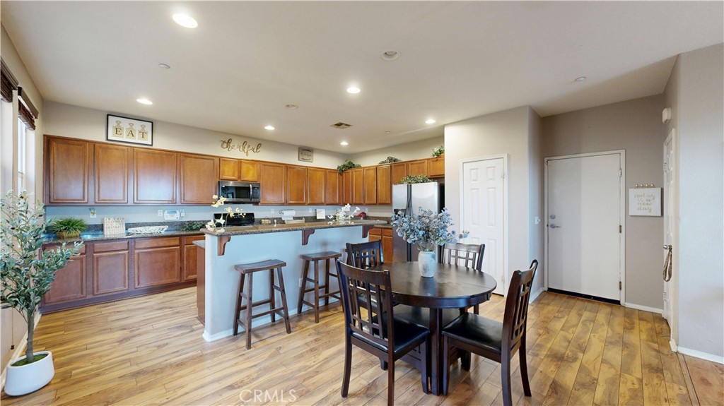 10375 Church Street, Unit 100 Rancho Cucamonga, CA 91730 - Photo 6 of 29 a kitchen with stainless steel appliances kitchen island granite countertop a dining table chairs and granite counter tops
