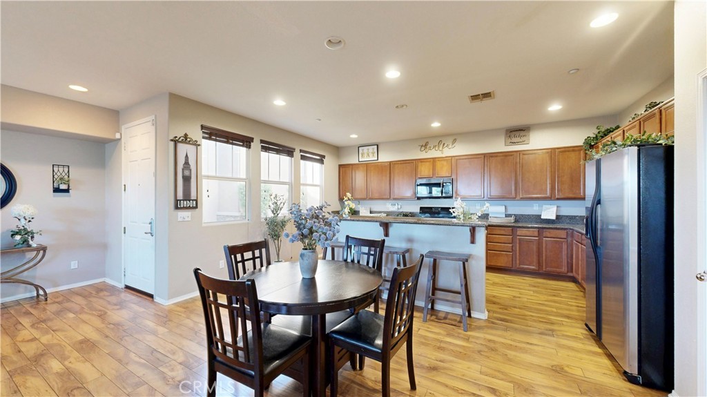 10375 Church Street, Unit 100 Rancho Cucamonga, CA 91730 - Photo 7 of 29 a kitchen with a dining table chairs and refrigerator