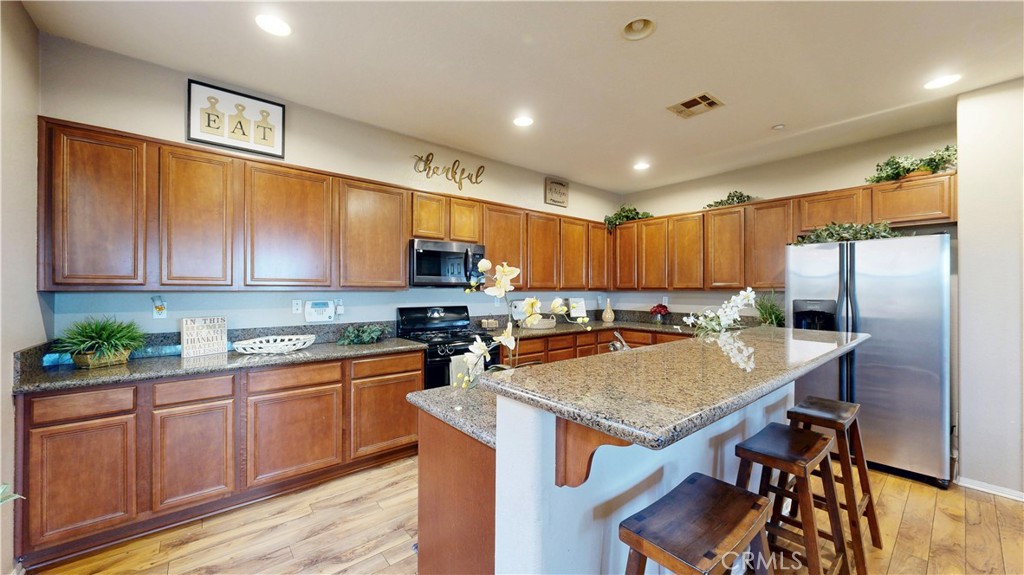 10375 Church Street, Unit 100 Rancho Cucamonga, CA 91730 - Photo 9 of 29 a kitchen with stainless steel appliances granite countertop a sink refrigerator and microwave
