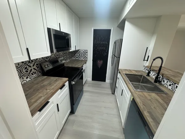 a kitchen with granite countertop a sink and a stove top oven