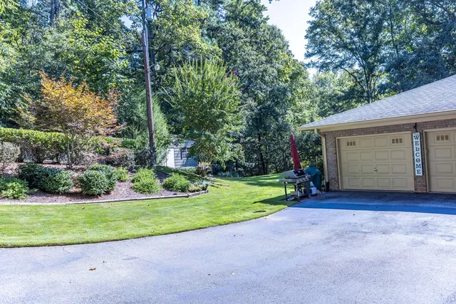 a view of a house with backyard and trees