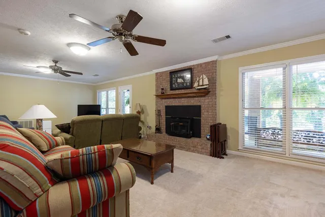 a living room with furniture a flat screen tv and a refrigerator