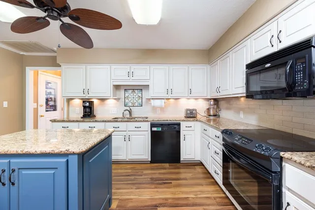 a kitchen with granite countertop a sink and steel appliances