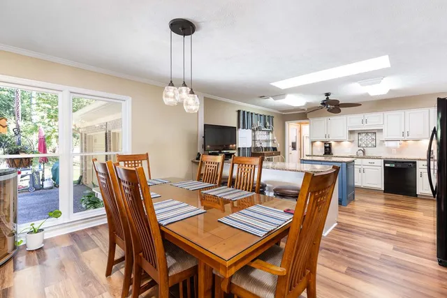 a view of a dining room with furniture a kitchen and chandelier