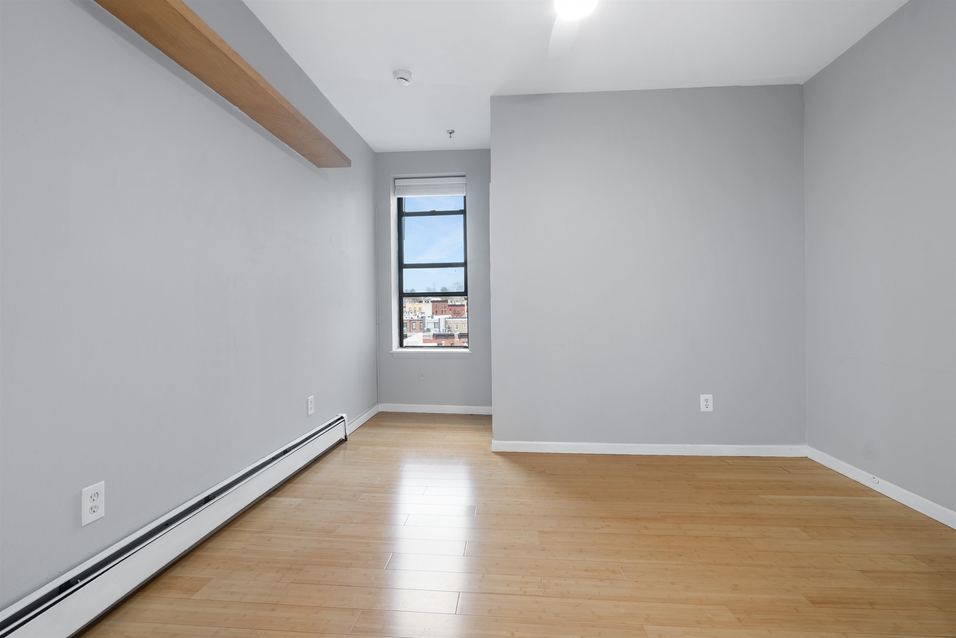 809 Park Avenue, Unit 9 Hoboken, NJ 07030 - Photo 13 of 30 an empty room with wooden floor and windows