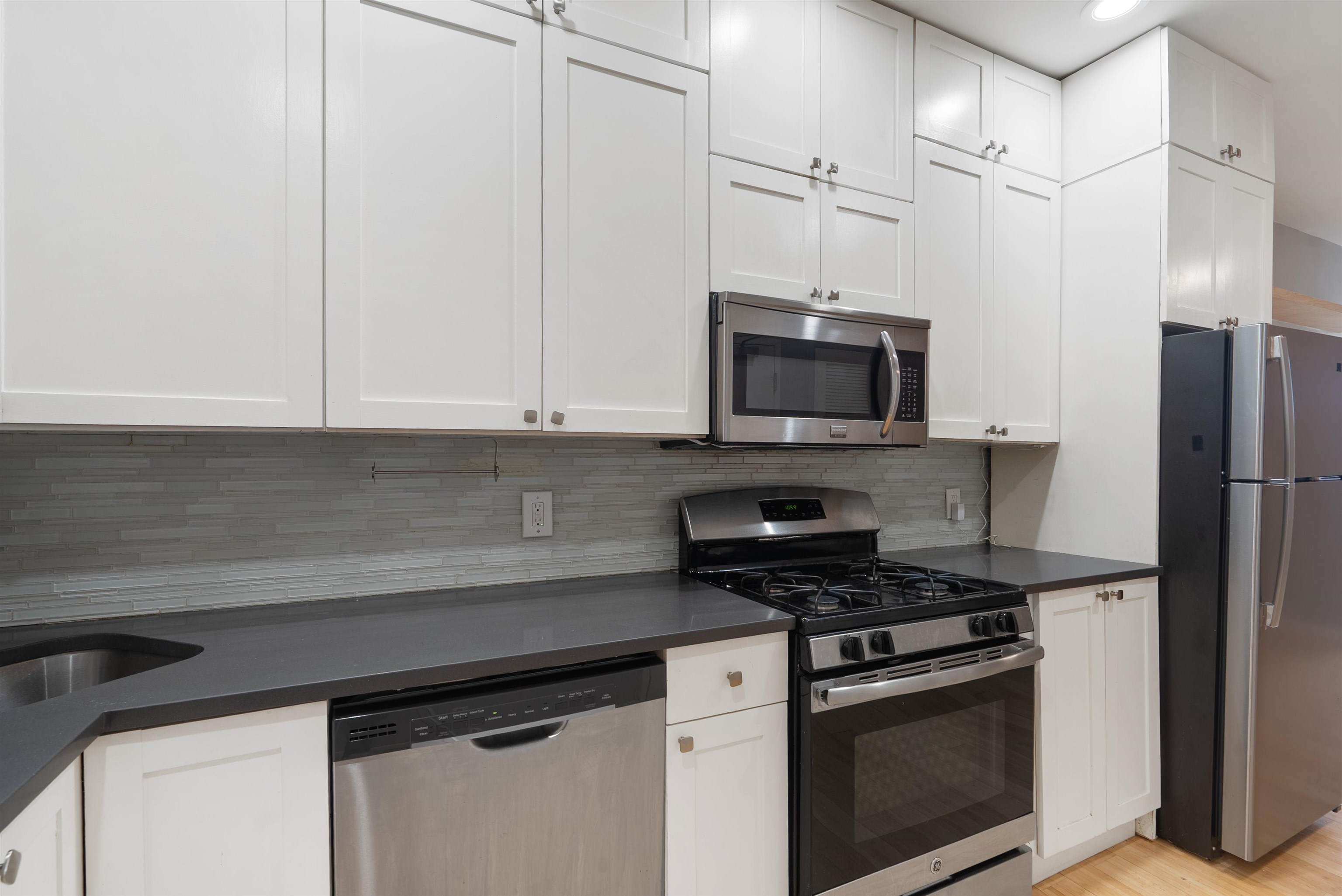 809 Park Avenue, Unit 9 Hoboken, NJ 07030 - Photo 7 of 30 a kitchen with stainless steel appliances a stove a microwave and a refrigerator