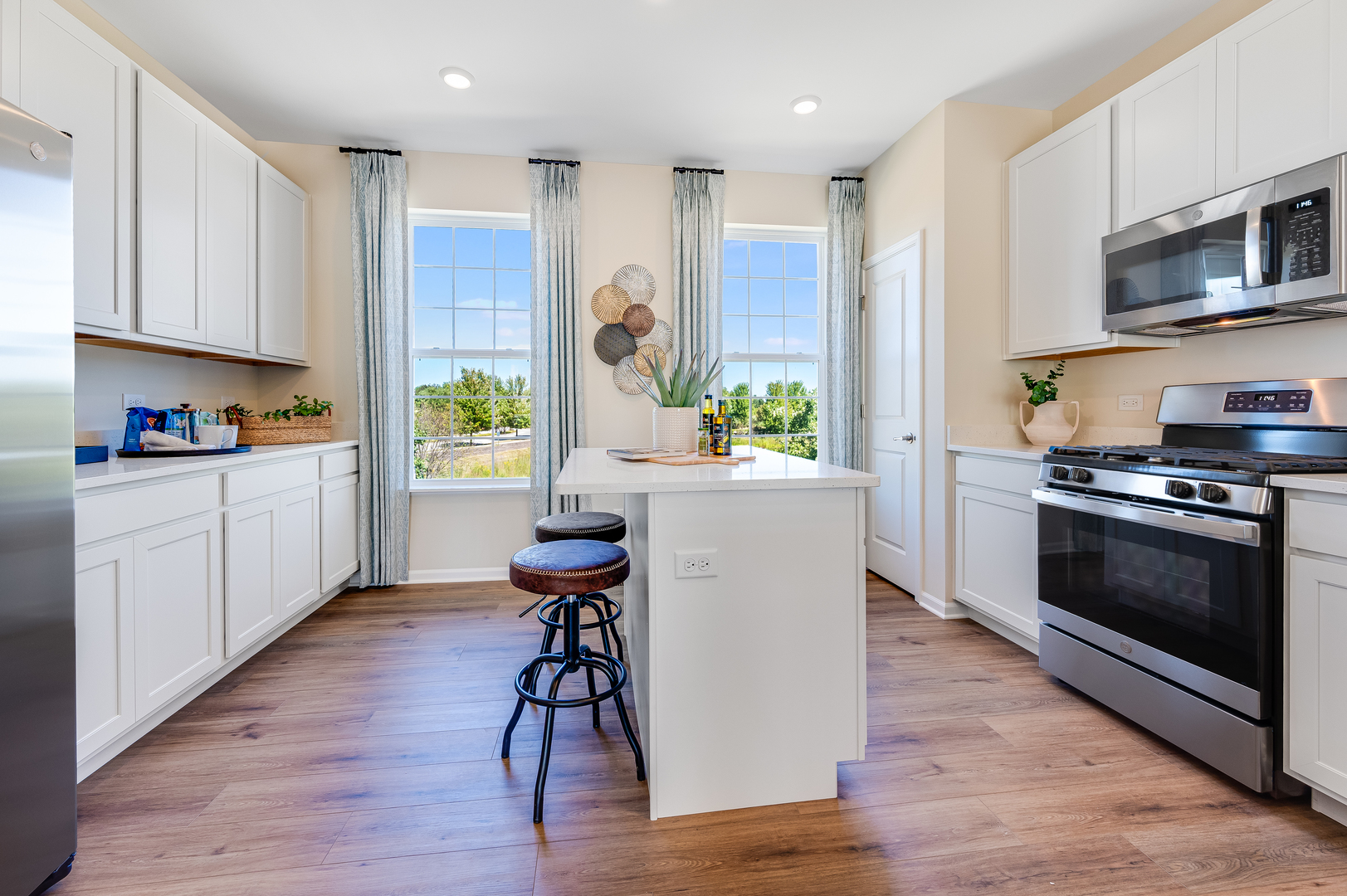 1701 Neubauer Circle Lindenhurst, IL 60046 - Photo 8 of 28 a kitchen with stainless steel appliances a stove a sink cabinets and a wooden floor