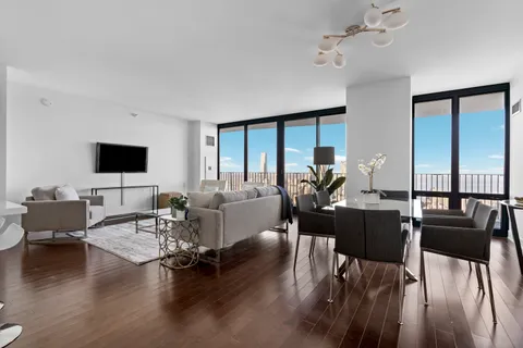 a living room with furniture flat screen tv and wooden floor
