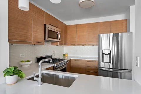 a kitchen with stainless steel appliances granite countertop a refrigerator and a sink