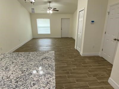 165 Meadow Road Lehigh Acres, FL 33973 - Photo 3 of 7 wooden floor in an empty room