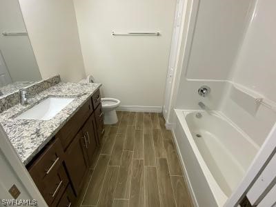 165 Meadow Road Lehigh Acres, FL 33973 - Photo 5 of 7 a bathroom with a granite countertop sink a toilet and shower
