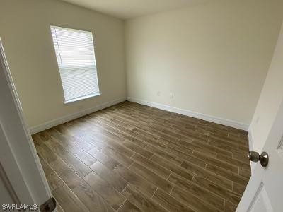 165 Meadow Road Lehigh Acres, FL 33973 - Photo 6 of 7 an empty room with wooden floor and windows