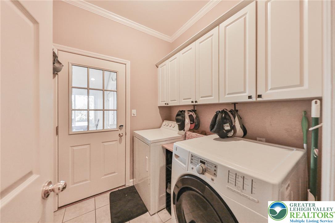 63 Long Road Lenhartsville, PA 19534 - Photo 55 of 100 Ample overhead cabinetry and classic crown molding elevate this functional laundry space.