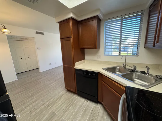 a kitchen with a sink cabinets and wooden floor