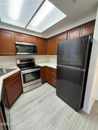 a kitchen with wooden cabinets and stainless steel appliances