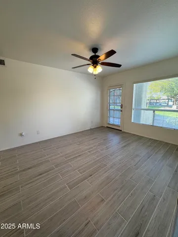 an empty room with wooden floor and windows