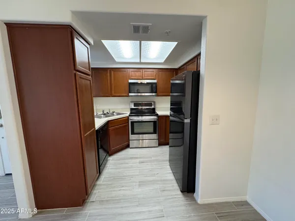 a kitchen with stainless steel appliances granite countertop a refrigerator and a stove