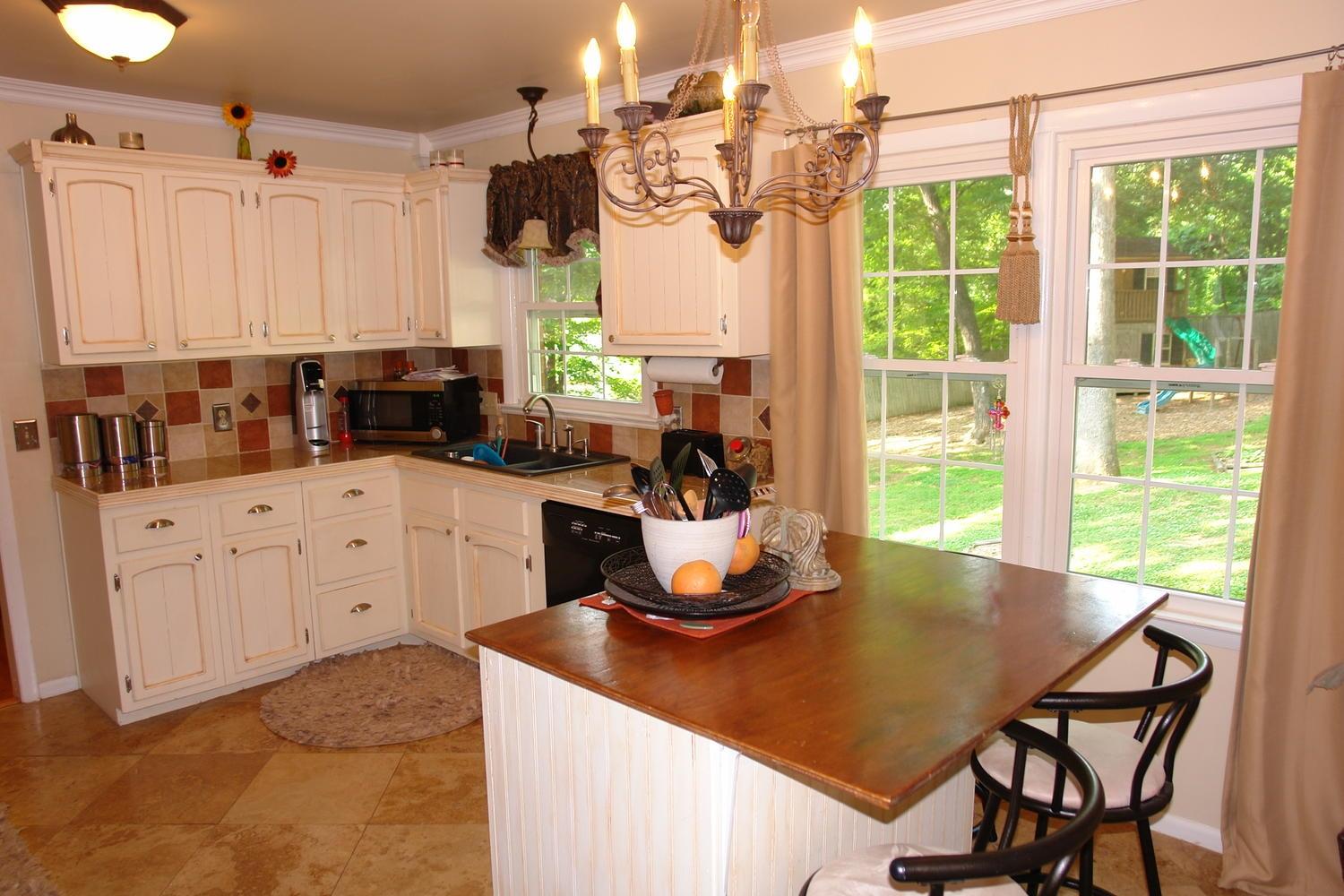 2969 Tree Swallow Road Roanoke, VA 24018 - Photo 8 of 31 a kitchen with a stove a sink and white cabinets with wooden floor