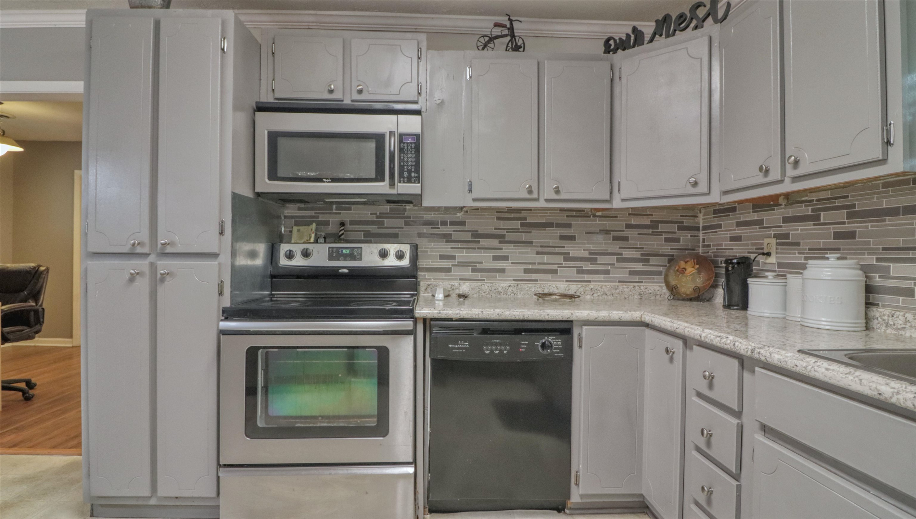 390 Lowery Road Medon, TN 38356 - Photo 12 of 24 a kitchen with granite countertop white cabinets stainless steel appliances and sink