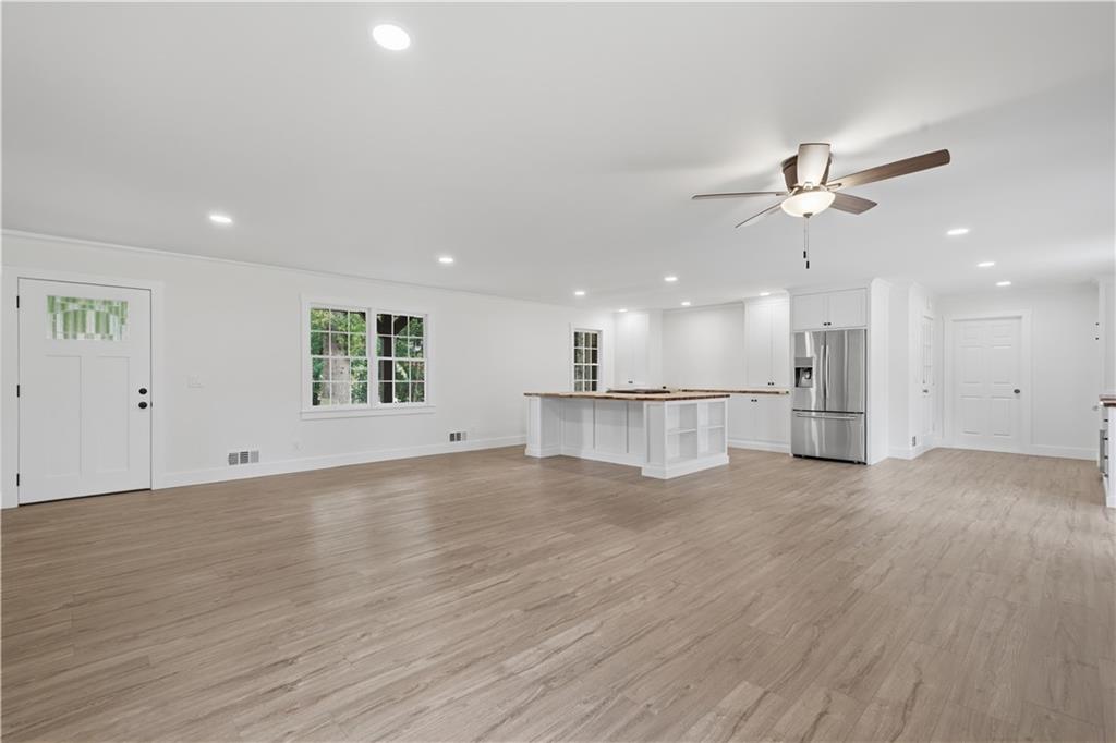 125 Childers Road Canton, GA 30115 - Photo 12 of 48 an empty room with wooden floor ceiling fan and windows