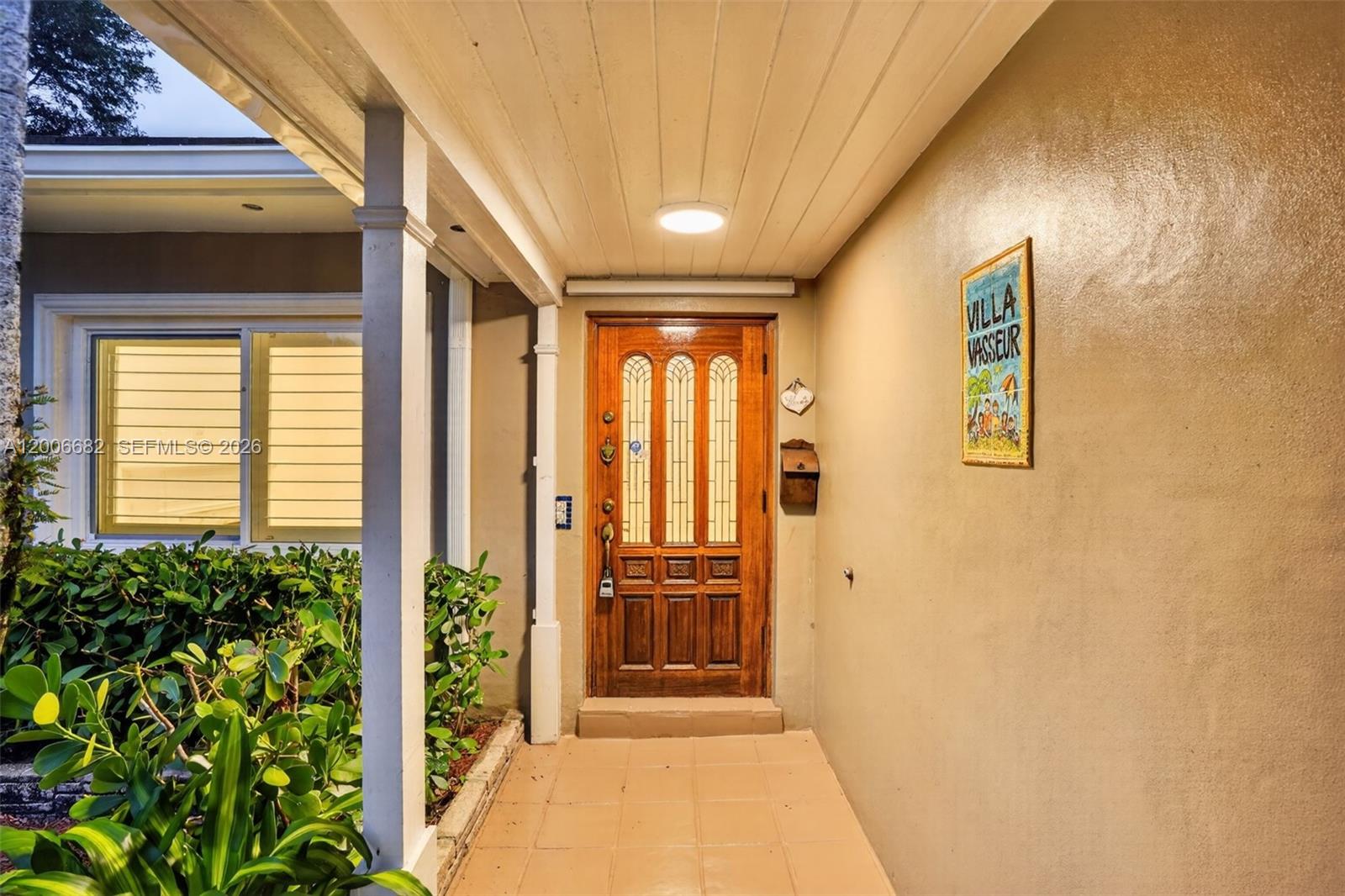 1435 Blue Road Coral Gables, FL 33146 - Photo 4 of 31 a view of a hallway with wooden floor and a potted plant
