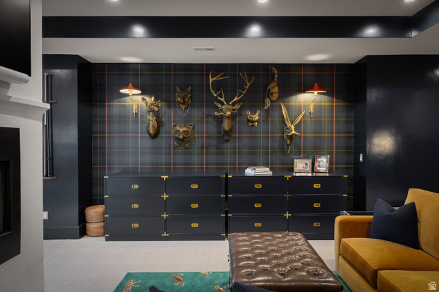558 West Rheinfalls Circle Midway, UT 84049 - Photo 25 of 61 Sophisticated entertainment space featuring custom black cabinetry with brass hardware, grid-pattern wall paneling with integrated display shelving, recessed ceiling lighting, and a tufted upholstered ottoman with complementary seating