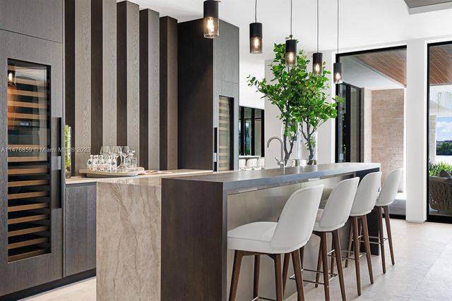 a kitchen with stainless steel appliances kitchen island a table chairs in it and wooden floors