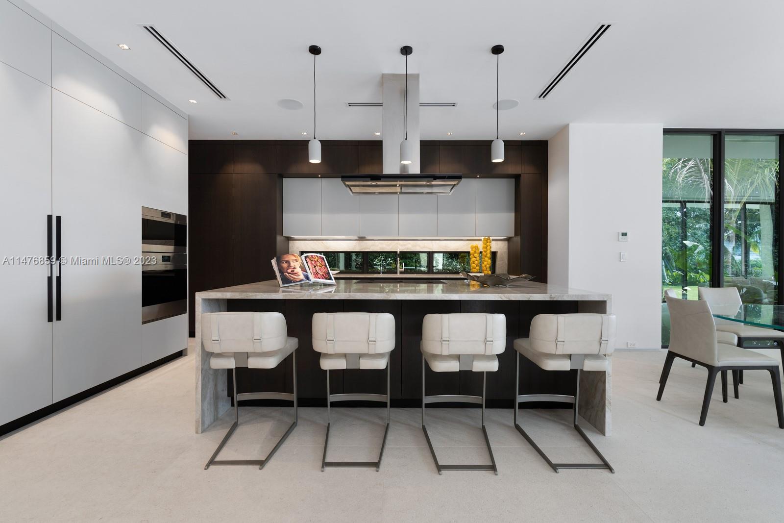 40 Palm Avenue Miami Beach, FL 33139 - Photo 14 of 62 a kitchen with stainless steel appliances kitchen island a table chairs in it and wooden floors