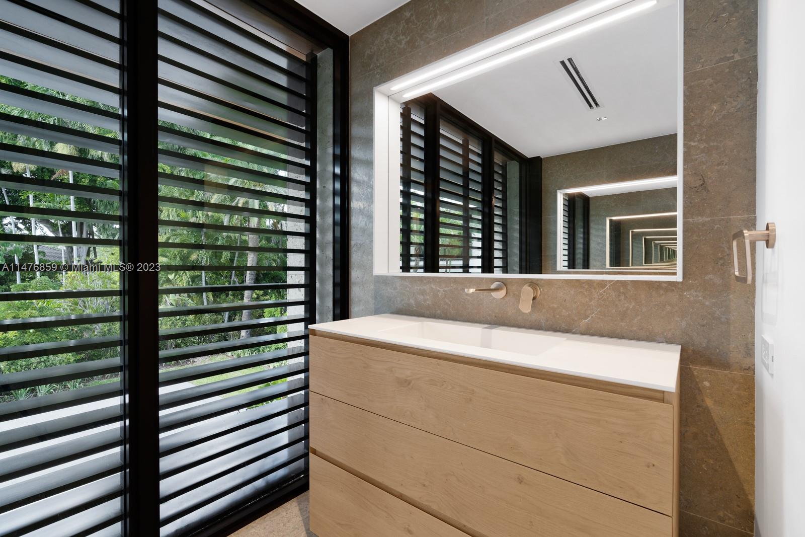 40 Palm Avenue Miami Beach, FL 33139 - Photo 44 of 62 a bathroom with a granite countertop sink and a mirror