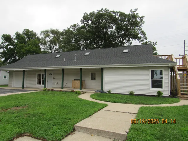 a front view of a house with a garden and yard