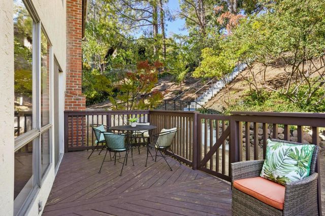 a balcony with wooden floor table and chairs