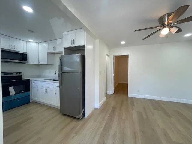 a kitchen with a refrigerator and a stove top oven