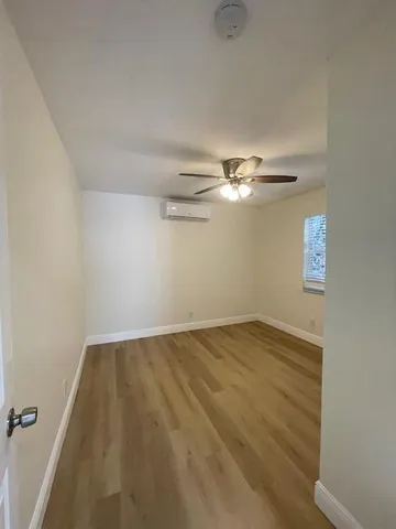a view of a room with wooden floor and ceiling fan