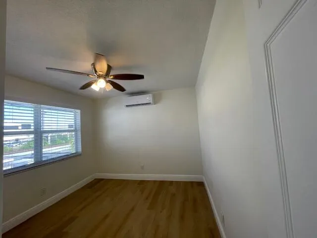 an empty room with a window and a fan