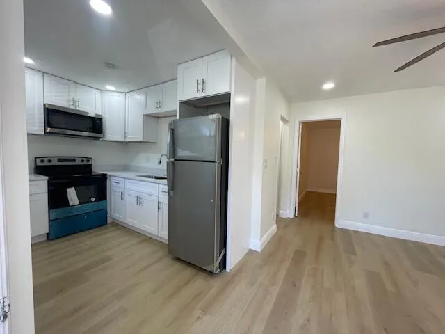 a kitchen with a refrigerator a stove top oven a sink and dishwasher