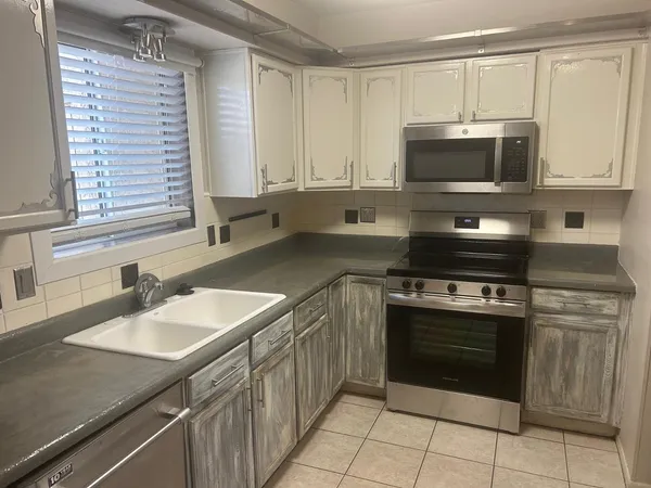 a kitchen with stainless steel appliances granite countertop a sink stove and microwave